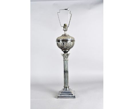 An Edwardian silver plated table lamp, of Corinthian column form with oval reservoir now converted to electric, supported on 