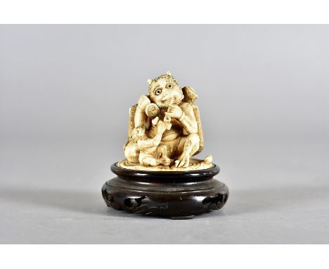 A Meiji period signed Japanese ivory netsuke, modelled as a horned mythical beast sitting with opium pipe accompanied with si