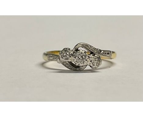 An 18ct gold three stone diamond crossover ring, illusion set stones, platinum bezel, size L, 2.6g 