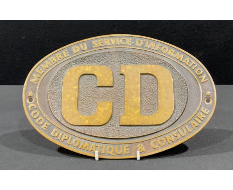 An oval bronze plaque, CD, Membre Du Service D'Information Code Diplomatique &amp; Consulaire, 29cm wide 