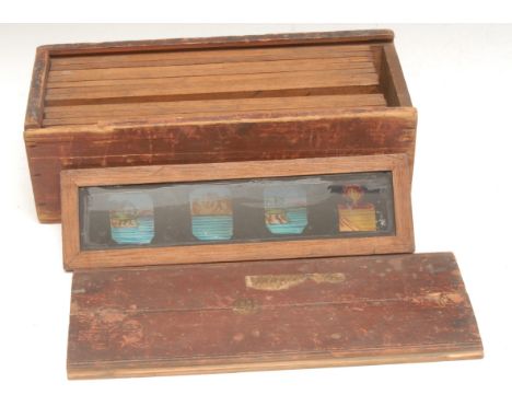 A set of 19th century mahogany framed magic lantern slides, comical figures and scenes, 21.5cm wide 