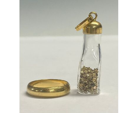 An 18ct gold wedding band, ring size M, 4.1g; an 18ct gold mounted pendant with gold flakes, 3g gross (2) 