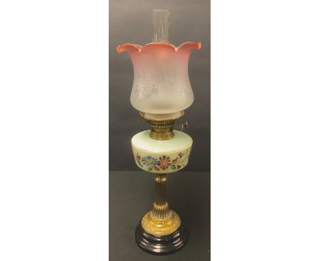 A Victorian brass oil lamp, opaque glass painted reservoir, cranberry flashed acid etched shade, glass chimney 