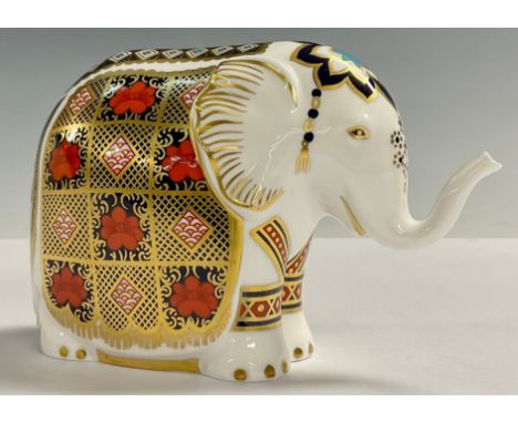 A Royal Crown Derby paperweight, Elephant, printed in the 1128 pattern, trunk raised, gold 21st anniversary stopper, 10.5cm, 