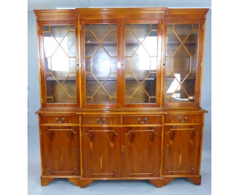 George III style yew breakfront cabinet bookcase, with an arrangement of four astragal glazed doors enclosing adjustable shel