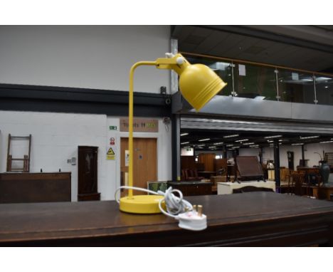 A metal bodied yellow bedside or desk lamp