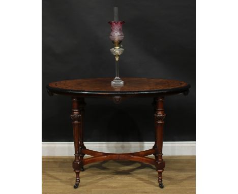 A Victorian Aesthetic Movement amboyna banded walnut and parcel-ebonised centre table, oval top, fluted tapered cylindrical s