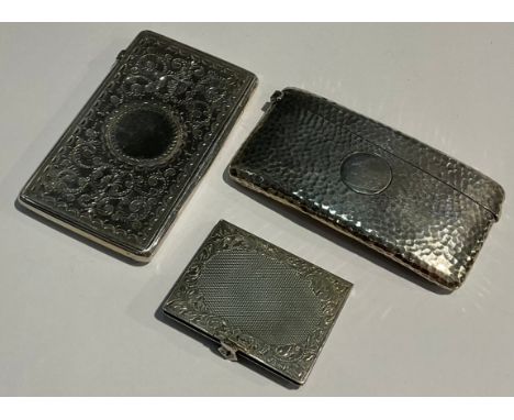 A Victorian silver rounded rectangular visiting card case, chased and engraved with leafy scrolls, vacant circular cartouche,