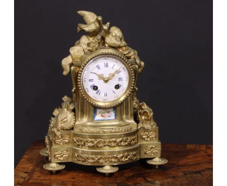 A French gilt brass mantel clock, crested with a pair of lovebirds and flaming torch, the white enamel dial with Roman and Ar