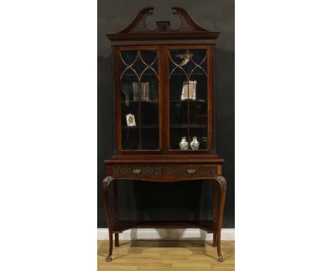 A Chippendale Revival mahogany display cabinet, fretwork swan neck pediment above a pair of glazed doors enclosing three shel