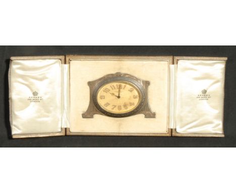 An Asprey &amp; Co Limited easel travelling timepiece, 6cm oval engine turned dial with radium Arabic numerals and hands, the