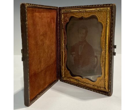 Photography - a 19th century ambrotype  photograph, of a young gentleman seated in a balloon back chair, tooled Morocco case,