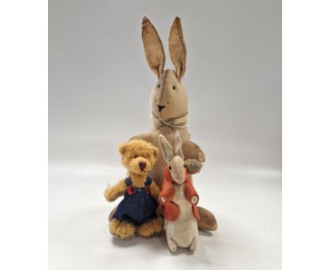 A felted rabbit teddy, early 20th century, posed seated and holding a carrot and wearing a colalr, inset with black eyes and 