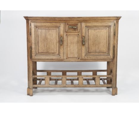 NINETEENTH CENTURY CONTINENTAL OAK SIDE CABINET, the canted oblong top above a pair of moulded  Cupboard doors, flanking a sh