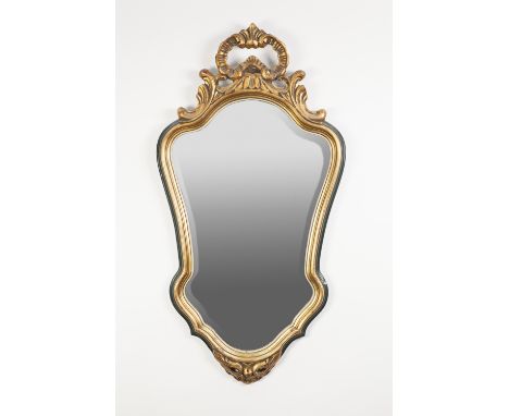 MODERN GILT AND GREEN PAINTED COMPOSITION WALL MIRROR IN THE ROCOCO STYLE, the shield shaped bevel edged plate in a moulded f
