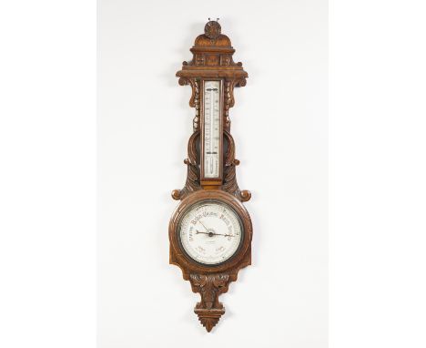 W. ARONSBERG, MANCHESTER, CARVED OAK ANERIOD BAROMETER, the 6" dial in a scroll carved banjo shaped case with a mercury therm
