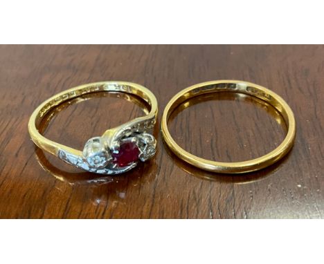 A ruby and diamond three stone ring, central red ruby dividing round brilliant cut diamond accents, 18ct gold shank, size L, 