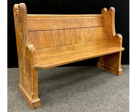 A 19th century pitch pine church pew, carved with a rose to each end, bible shelf to back, 97cm high x 136cm wide x 50cm deep