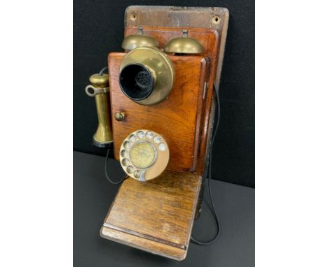 An early 20th century mahogany cased wall mounted telephone.