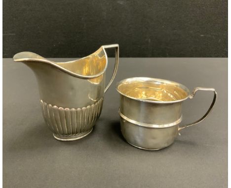 An Edwardian silver gadrooned milk jug, William Hutton &amp; Sons Ltd, London 1903;  a Christening cup, Birmingham 1934, 5.6o