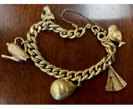 An 18ct gold charm bracelet with five charms, fan, fish, coffee pot etc.  Part stamped 750, part unmarked 29.1g gross