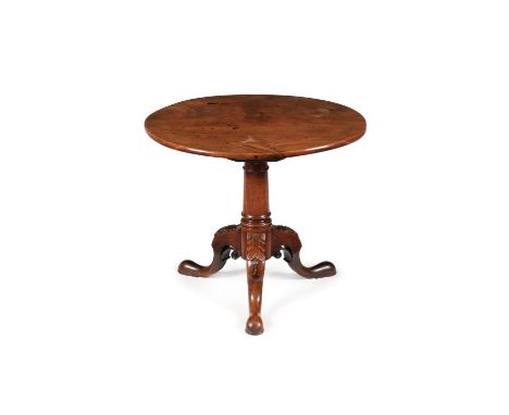 A George III mahogany tripod table, circa 1760, the hinged top above the turned tapering stem, on acanthus carved and scroll 