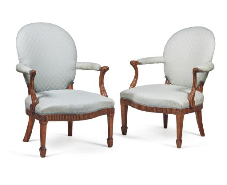 A matched pair of George III mahogany and upholstered open armchairs, circa 1770, each shaped and padded oval back above a pa