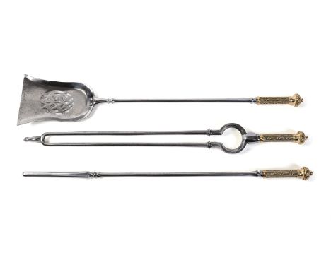 A set of Gothic Revival steel and brass mounted fire tools, mid-19th century, comprising shovel, poker and tongs, the grips c