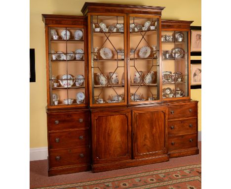 A George III mahogany breakfront library bookcase, circa 1780, the moulded cornice above four astragal glazed doors opening t