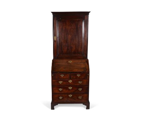 A George II mahogany bureau bookcase, circa 1740, the cavetto moulded cornice above a moulded panel door opening to a shelved