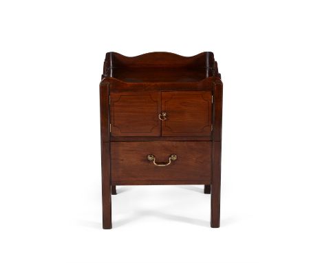 A George III mahogany night commode, circa 1780, with shaped gallery incorporating pierced side carrying handles, above a pai