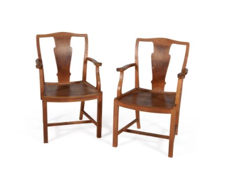 A pair of oak open armchairs, by HEAL'S, circa 1920, in the Cotswold style, each shaped top rail above a vase shaped splat, f