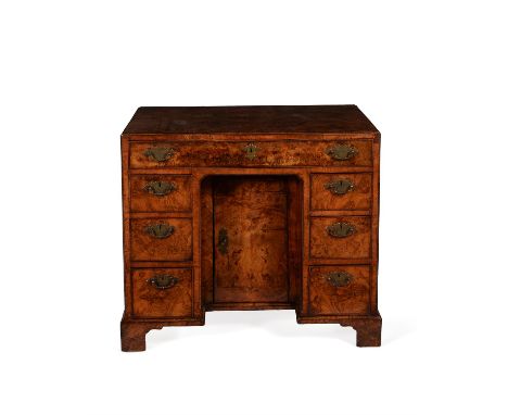 A George II figured walnut and crossbanded kneehole desk, circa 1740, the caddy moulded rectangular top, above a frieze draw,