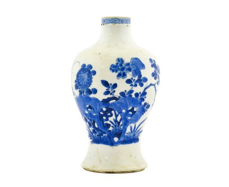 A Chinese Porcelain Vase, Kangxi, of baluster form, painted in underglaze blue with foliage amongst rockwork below a scroll b