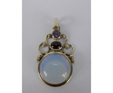 A Silver and Moonstone Pendant, the pendant set with garnet and amethysts, moonstone 20 mm, garnet 8 x 6 mm, amethyst 6 mm.
