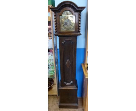 An Oak Cased Brass Face Chiming Grandmother Clock, the clock having five gong rods with Roman numerals, barley twist columns 
