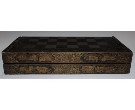 An early 19th century Chinese export lacquer rectangular games box, decorated in gilt with a chess board, the sides with vign