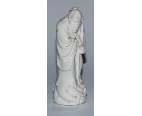 A Chinese blanc de chine figure, of an immortal holding a scroll, 14.5cm high 