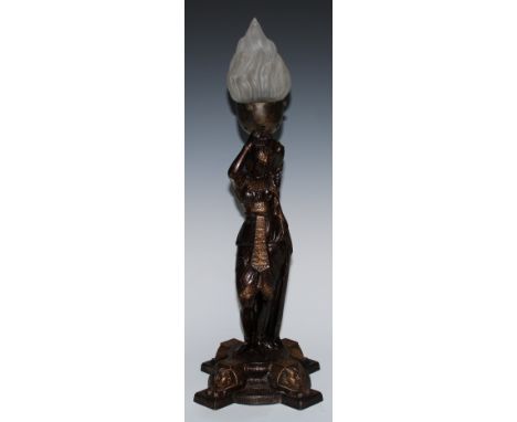 An Egyptian Revival spelter table lamp, cast as a court dancer, the cruciform base with sphinxes, frosted glass flame-moulded