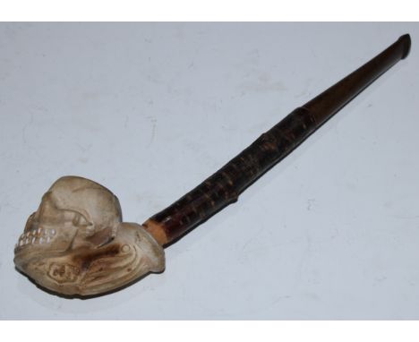 A 19th century French macabre novelty clay pipe, by Gambier of Paris, as a skull, the memento mori bowl moulded with skeletal