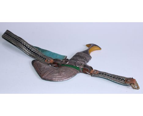 A Middle Eastern silver coloured metal mounted jambiya, 15cm curved blade, filigree scabbard, 28cm long overall 