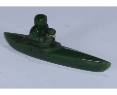 An Inuit nephrite jade carving, of a figure in a canoe, 13cm long 