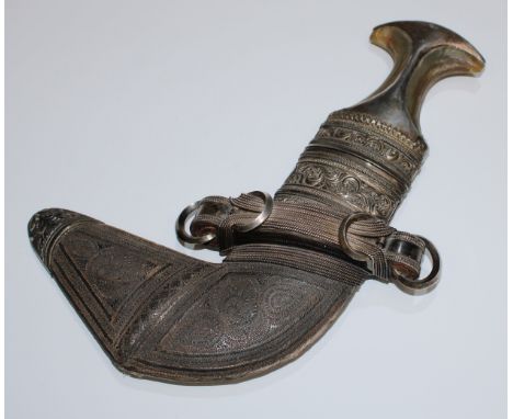 A Middle Eastern silver mounted jambiya dagger, 17cm curved blade with central ridge, horn grip, the leather scabbard with ch