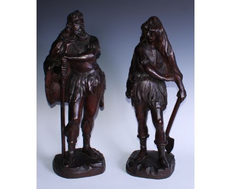 A pair of 19th century oak carvings, of Teutonic figures, one with an axe, his bearded companion with a rugged staff, 55cm an