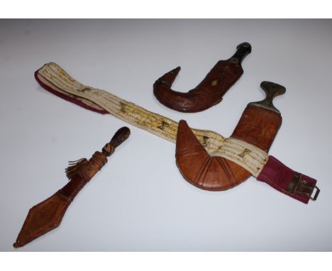 A Middle Eastern jambiya dagger, 21cm curved blade with central ridge, horn handle, leather scabbard, 35cm long overall; anot