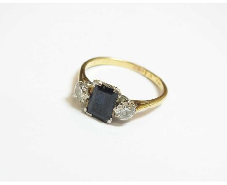 A three stone sapphire and diamond ring, designed as a central rectangular cut sapphire flanked to each side by a brilliant c