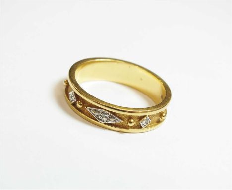 An 18ct gold diamond set band, the three faceted stones set in white gold to textured band, ring size O, weight approx 4.4g