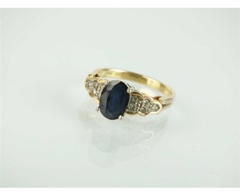 A sapphire and diamond ring, designed as a central oval mixed cut sapphire claw set in white metal and mounted to diamond set
