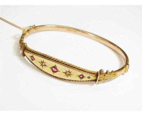 A Victorian 9ct gold diamond and paste hinged bangle, designed as three graduated red faceted pastes interspersed with two ro