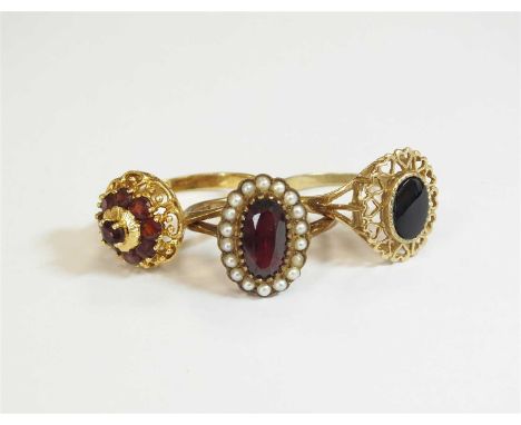 A 9ct gold garnet and seed pearl oval cluster ring, hallmarked Chester 1960, size N, together with a garnet cluster ring, sta